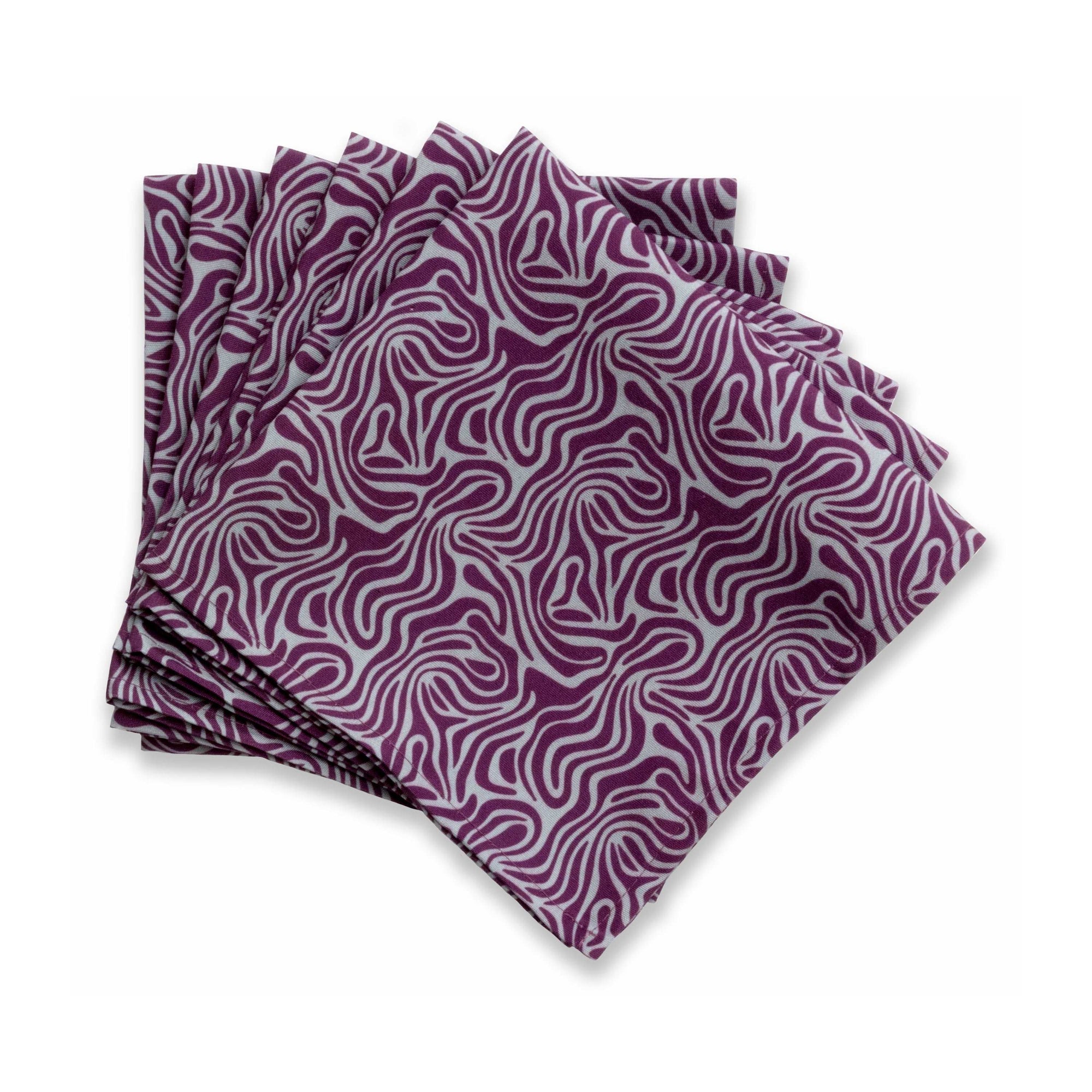 Bright patterned cloth napkin with quarter-inch hem. Base color is stone grey with amorphous layers of dark purple. The back is the base color with small, discreet dark grey logo on bottom left-hand side. View: 6 napkins folded into quarters and fanned out, with pattern side exposed and top left corner folded down to expose back side.