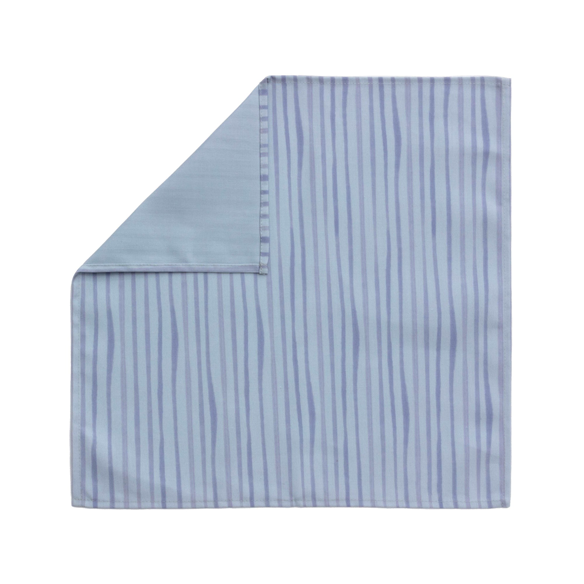 Bright cloth napkin with a pattern of painterly stripes, with quarter-inch hem. Base color is cornflower blue, with alternating stripe of concord purple. The back is the solid base color with small, discreet dark grey logo on bottom left-hand side. View: 1 napkin laid flat with pattern side exposed and top left corner folded down to expose back side.